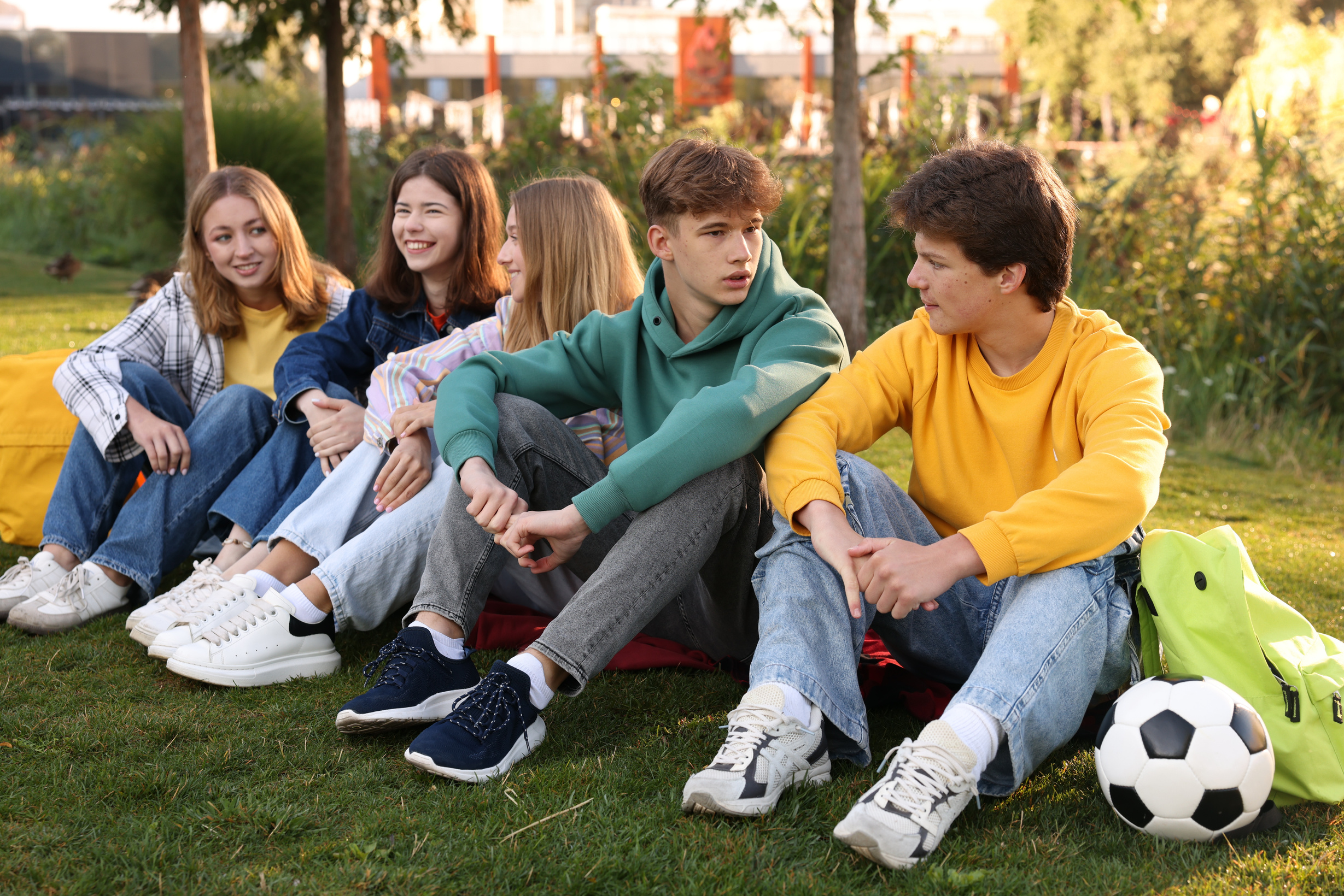Skupina teenageřů sedících společně na trávě